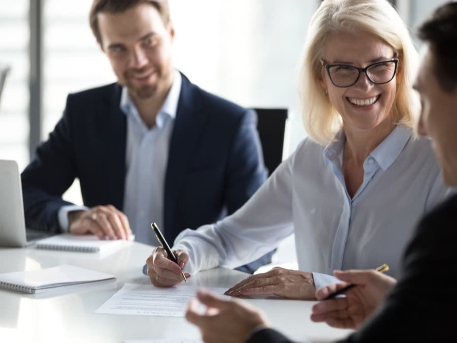 Three Businesspeople Smiling In A Meeting